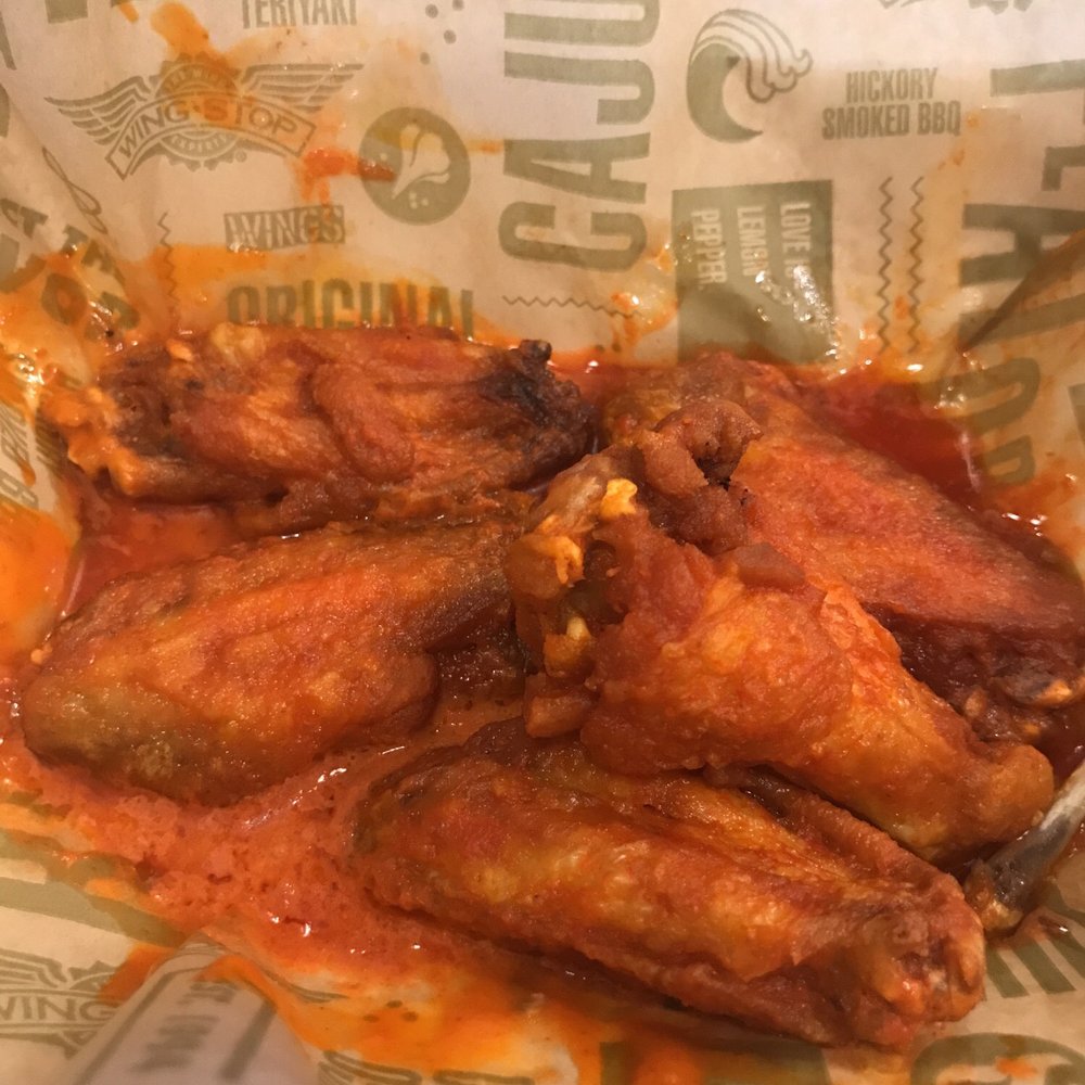 a basket of chicken wings with sauce a basket of chicken wings with sauce
