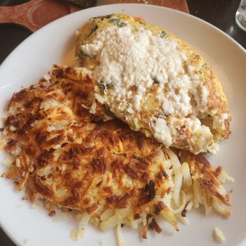 The Blossom Cafe - A breakfast plate featuring an omelette with cheese and vegetables, alongside crispy hash browns with shredded potatoes. - Breakfast & Brunch Near Me - Norridge, Illinois