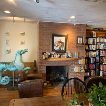 Brown Mustache Coffee - a living room with a fireplace and bookshelves - Coffee & Tea Near Me - Annapolis, Maryland