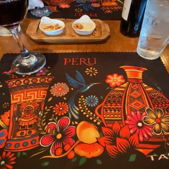 Inca's Peruvian Cuisine - a table with a placemat and a glass of wine - Latin American Near Me - Tucson, Arizona