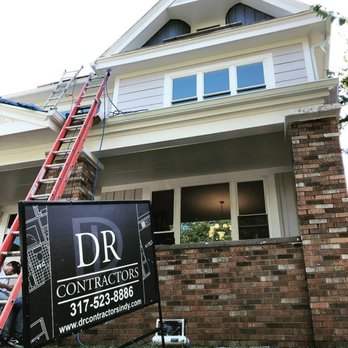 DR Contractors - a man on a ladder in front of a house - General Contractors Near Me - Indianapolis, Indiana