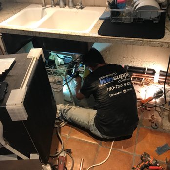 Ace Plumbing - a man fixing a sink in a kitchen - Plumbing Near Me - Escondido, California Ace Plumbing - a man fixing a sink in a kitchen - Plumbing Near Me - Escondido, California