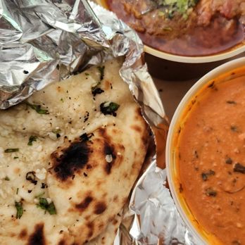 Bismillah Kabob N Curry Cafe - Butter chicken and garlic naan and tilapia curry pictured on top. - Indian Near Me - Warren, Michigan