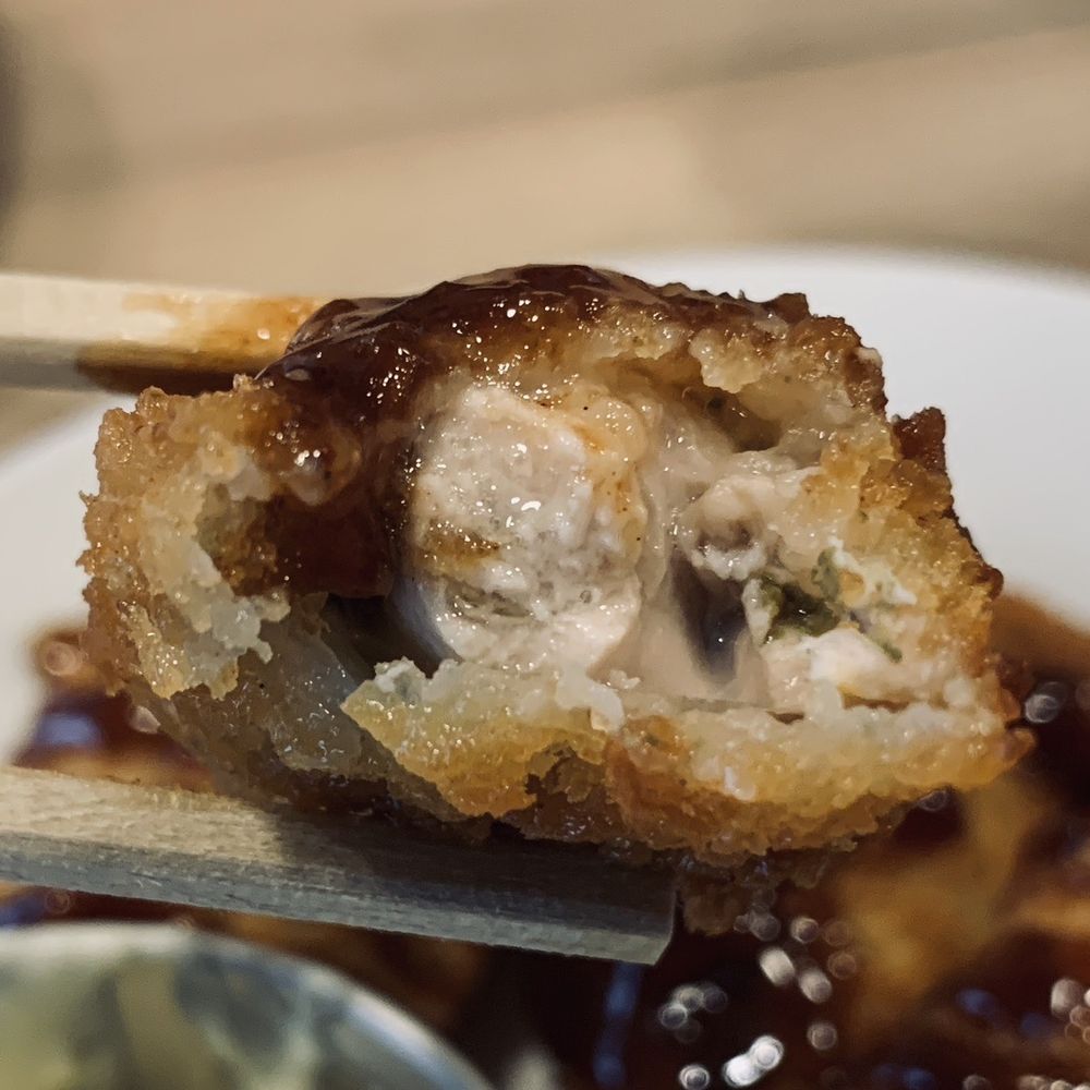 a close up of a fried sushi on a plate with chopsticks a close up of a fried sushi on a plate with chopsticks