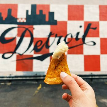 Olga's Kitchen - a hand holding a piece of pizza - Sandwiches Near Me - Allen Park, Michigan Olga's Kitchen - a hand holding a piece of pizza - Sandwiches Near Me - Allen Park, Michigan