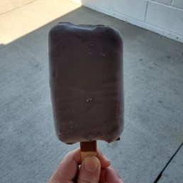a hand holding a chocolate covered ice lolly a hand holding a chocolate covered ice lolly