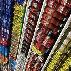 Crescent Market - Grocery shelves neatly stocked with international and local favorites -- from sauces and canned goods to condiments and more!