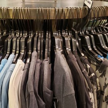 Volcom - A clothing rack holds hoodies and sweatshirts in different colors and patterns inside a retail store, with promotional signs visible in the background. - Fashion Near Me - Sunrise, Florida