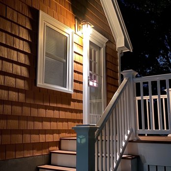 Boston Exterior Remodeling - side porch at night, composite deck, excellent extended roof profile that makes the house look bigger (really!) - General Contractors Near Me - West Roxbury , Massachusetts Boston Exterior Remodeling - side porch at night, composite deck, excellent extended roof profile that makes the house look bigger (really!) - General Contractors Near Me - West Roxbury , Massachusetts