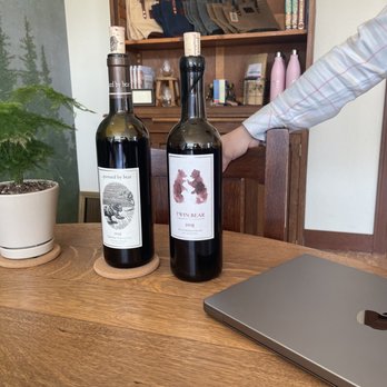 Pursued By Bear - two bottles of wine and a laptop - Wine Tasting Room Near Me - Walla Walla, Washington