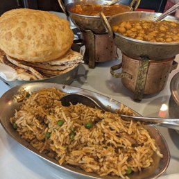 Biryani with a basket of different bread. Lamb vindaloo and chicken curry Biryani with a basket of different bread. Lamb vindaloo and chicken curry