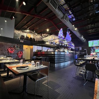 Fritti - a dining area with a large screen in the background - Italian Near Me - Atlanta, Georgia Fritti - a dining area with a large screen in the background - Italian Near Me - Atlanta, Georgia