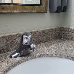 The wall mirror has a nice frame around it, not a builder grade design. Granite counter with a modern drop in sink.