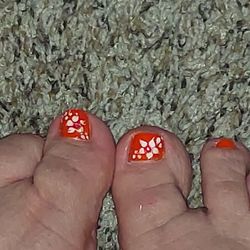 Famous Nails - Simple flowers. Don't match. My left flower is way different. Also, you can see where she got white and orange paint on the top of my foot