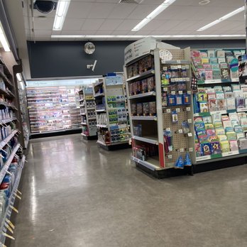 Walgreens - A store aisle with shelves filled with stationery, greeting cards, and office supplies, illuminated by fluorescent lighting. - Drugstores Near Me - Elm Grove, Wisconsin