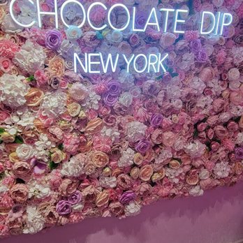 Chocolate DIP - a wall of flowers with a neon sign - Creperies Near Me - New York, New York