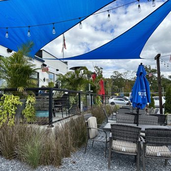 Charlys Waterfront - a patio area with tables and umbrellas - Burgers Near Me - Essex, Maryland