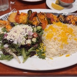 This is a juicy chicken kabob with basmati rice and a Greek salad.
