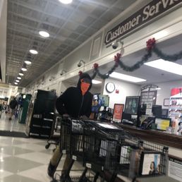 A worker with mask under his nose not protecting others on a very crowded Christmas eve