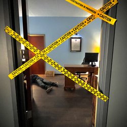 A sneak peak of the CSI escape room with caution tape over the doorway blocking your path.