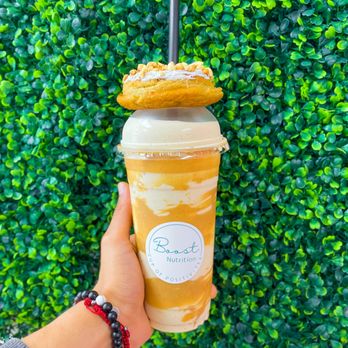 Boost Nutrition - a hand holding a cup of iced coffee with a cookie on top - Juice Bars & Smoothies Near Me - Streamwood, Illinois