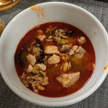 Lim's Kitchen - Seafood Soondubu Jjigae (Tofu Soup/Stew), this is about half poured into my own bowl - Chicken Wings Near Me - Astoria, New York Lim's Kitchen - Seafood Soondubu Jjigae (Tofu Soup/Stew), this is about half poured into my own bowl - Chicken Wings Near Me - Astoria, New York
