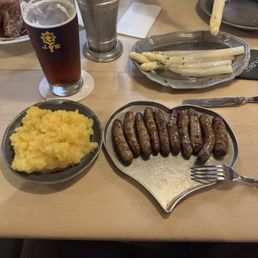 Sausages, potato salad, and asparagus salad