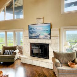 BOND'S Television & Electronics - Samsung Frame TV mounted on a stone fireplace by Bonds TV