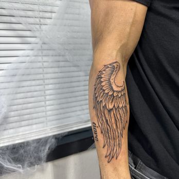 Njoy Ink Studios - Angel wing, black and grey realism, arm tattoo with font - Tattoo Near Me - Coeurdalene, Idaho Njoy Ink Studios - Angel wing, black and grey realism, arm tattoo with font - Tattoo Near Me - Coeurdalene, Idaho