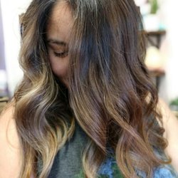 Gray's Hair Studio - Long brunette hair with warm caramel balayage, beachy waves, and natural movement for a sun-kissed style.