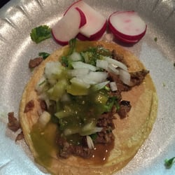 Asada taco with onions, cilantro and green salsa. Radishes on the side.