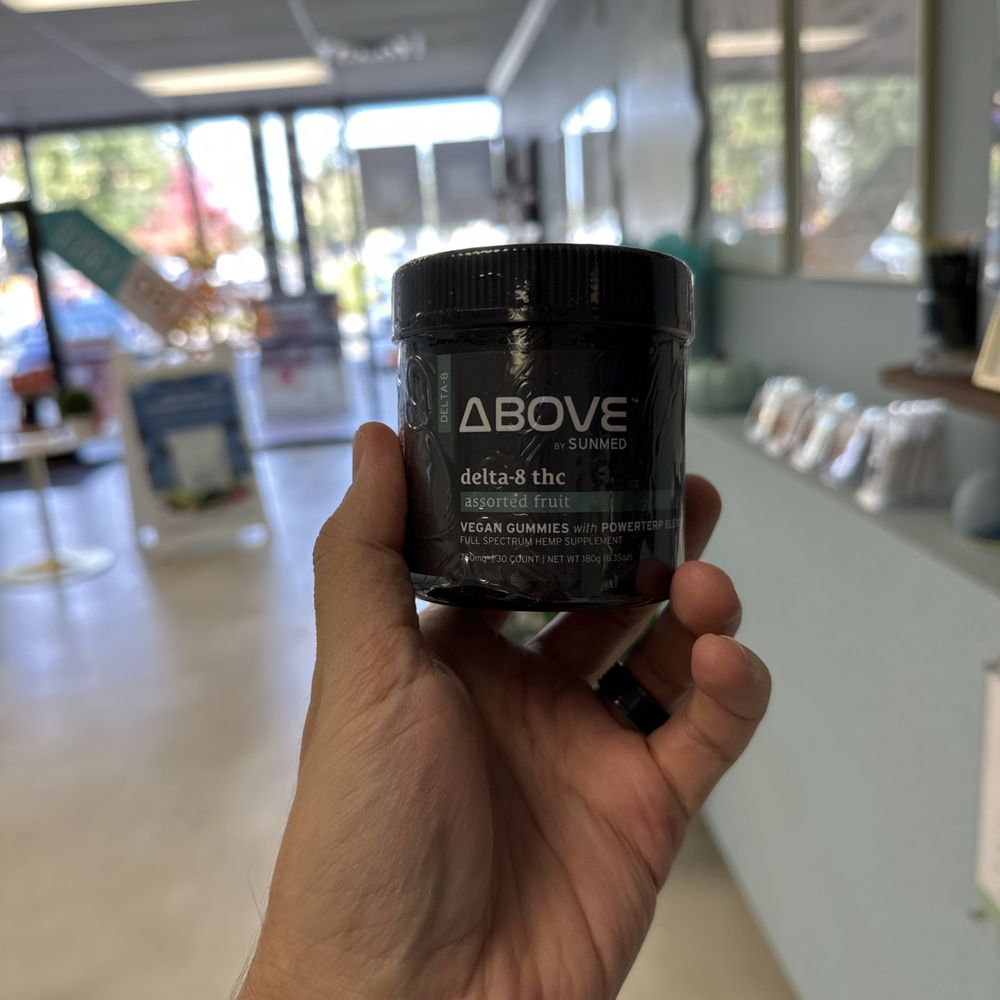 a hand holding a jar of cbd cream a hand holding a jar of cbd cream