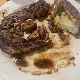 a plate of steak and a baked potato