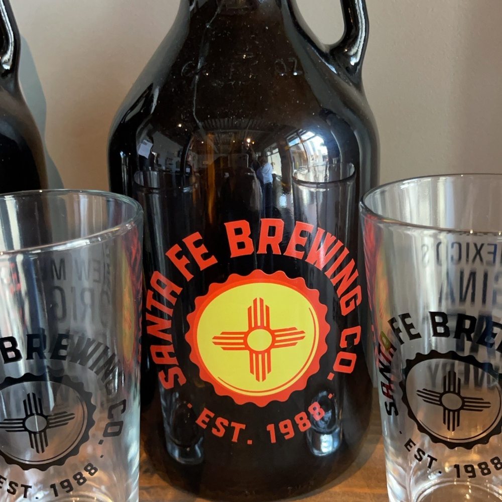 Santa Fe Brewing - a growl of beer and two shot glasses - Breweries Near Me - Santa Fe, New Mexico