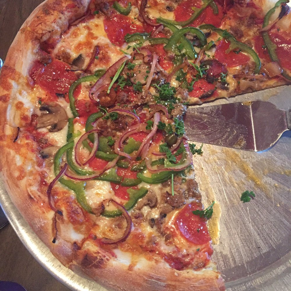 Big Mike's - a pizza with a slice taken out of it - Pizza Near Me - Brevard, North Carolina