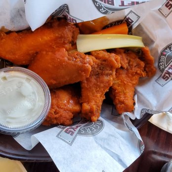 Draft Picks - Hot wings - Basket of fried chicken wings with celery stalk and a side of ranch dipping sauce, served on branded paper liner. - Sports Bars Near Me - Mount Prospect, Illinois