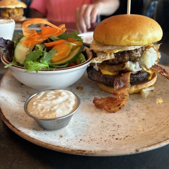 State Fare Kitchen & Bar - Hangover burger. Hamburger patty and sausage patty, along with bacon on this burger. - New American Near Me - Houston, Texas