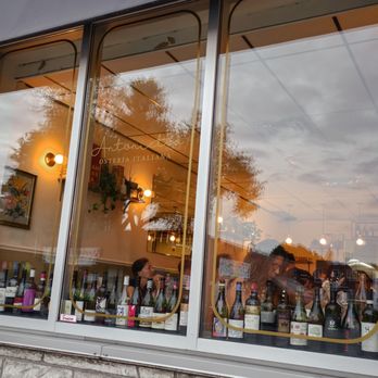 Antonietta - the reflection of a group of people in a wine shop window - Italian Near Me - Montreal, Quebec