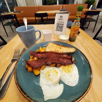 Craft PDX - Hi-Lo breakfast with 2 over easy eggs, potatoes, amazing bacon, and gluten-free toast. Coffee with almond milk. Cholula hot sauce. - New American Near Me - Portland, Oregon