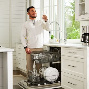 Culligan - Man looking at spot-free glass from dishwasher using Culligan's soft water - Water Purification Services Near Me - Coleman, Michigan Culligan - Man looking at spot-free glass from dishwasher using Culligan's soft water - Water Purification Services Near Me - Coleman, Michigan