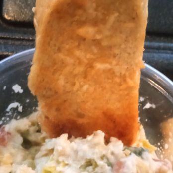 Ruby River Steakhouse - Parmesan bread dipping in artichoke dip - Steakhouses Near Me - Salt Lake City, Utah