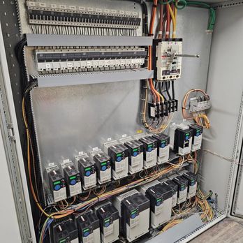 Tarin Electric & Lighting - Industrial electrical control panel featuring multiple variable frequency drives (VFDs), circuit breakers, and organized wiri... - Electricians Near Me Tarin Electric & Lighting - Industrial electrical control panel featuring multiple variable frequency drives (VFDs), circuit breakers, and organized wiri... - Electricians Near Me