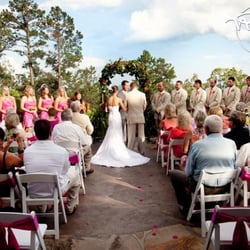 An Enchanting Evening - Bride and Groom say their vows.  120 white wedding chairs included in venue rental.  Pinnacle mountain backdrop - little rock