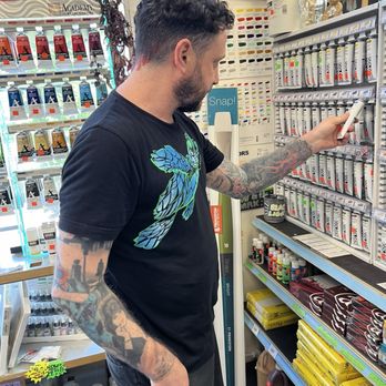 Art Supply Center - Handsome man shopping acrylic paint - Art Supplies Near Me - Portland, Oregon