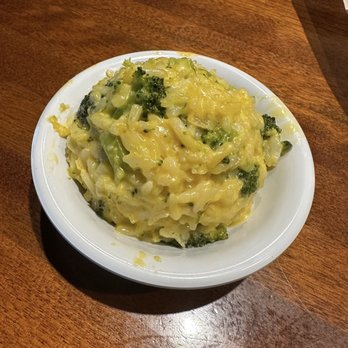 Cheddar's Scratch Kitchen - Broccoli Cheese Casserole - A serving of broccoli cheese casserole with broccoli florets and melted cheese in a white bowl on a wooden table. - Comfort Food Near Me - Findlay, Ohio