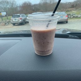a smoothie in a plastic cup on the dashboard of a car a smoothie in a plastic cup on the dashboard of a car