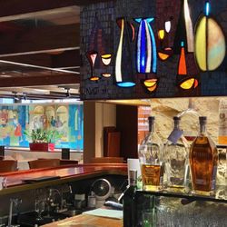 Corner of the bar with its backlit mosaic and a mural of the titular beachcomber in the background