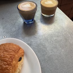 Cortado and macchiato alongside a choc croissant Cortado and macchiato alongside a choc croissant