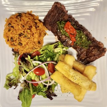 Caribella - Churrasco (skirt steak) platter with yuca fries, arroz con gandules & home made chimichurri. - Caribbean Near Me - Chicago, Illinois Caribella - Churrasco (skirt steak) platter with yuca fries, arroz con gandules & home made chimichurri. - Caribbean Near Me - Chicago, Illinois