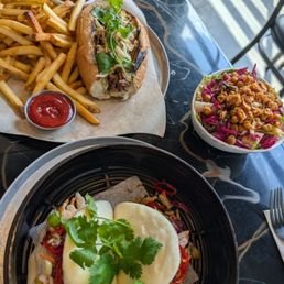 Braised lamb sandwich on top, Tofu Sweet potato bao buns with side salad next to sandwich Braised lamb sandwich on top, Tofu Sweet potato bao buns with side salad next to sandwich